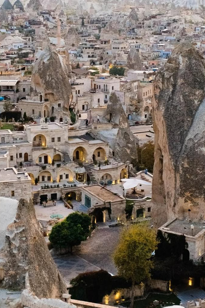 Stalactite-shaped buildings in a cave town, likely in Cappadocia, Turkey.